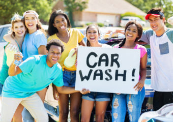 Car wash for SCF Group of young people holding a car wash sign scf